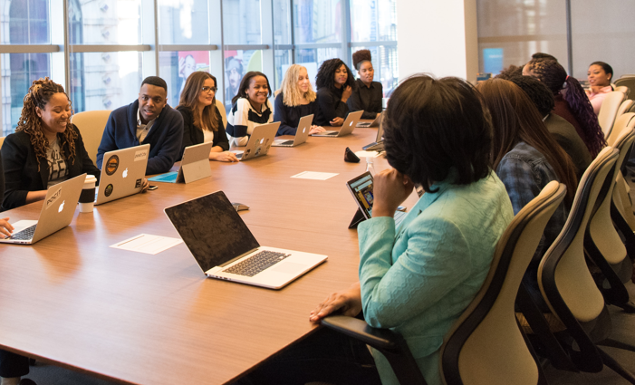 Large board room table with many people seated.
